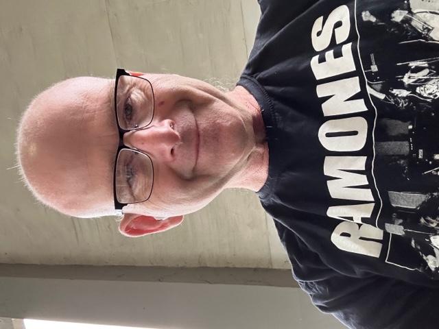 Picture of your instructor smiling and wearing a Ramones t-shirt 