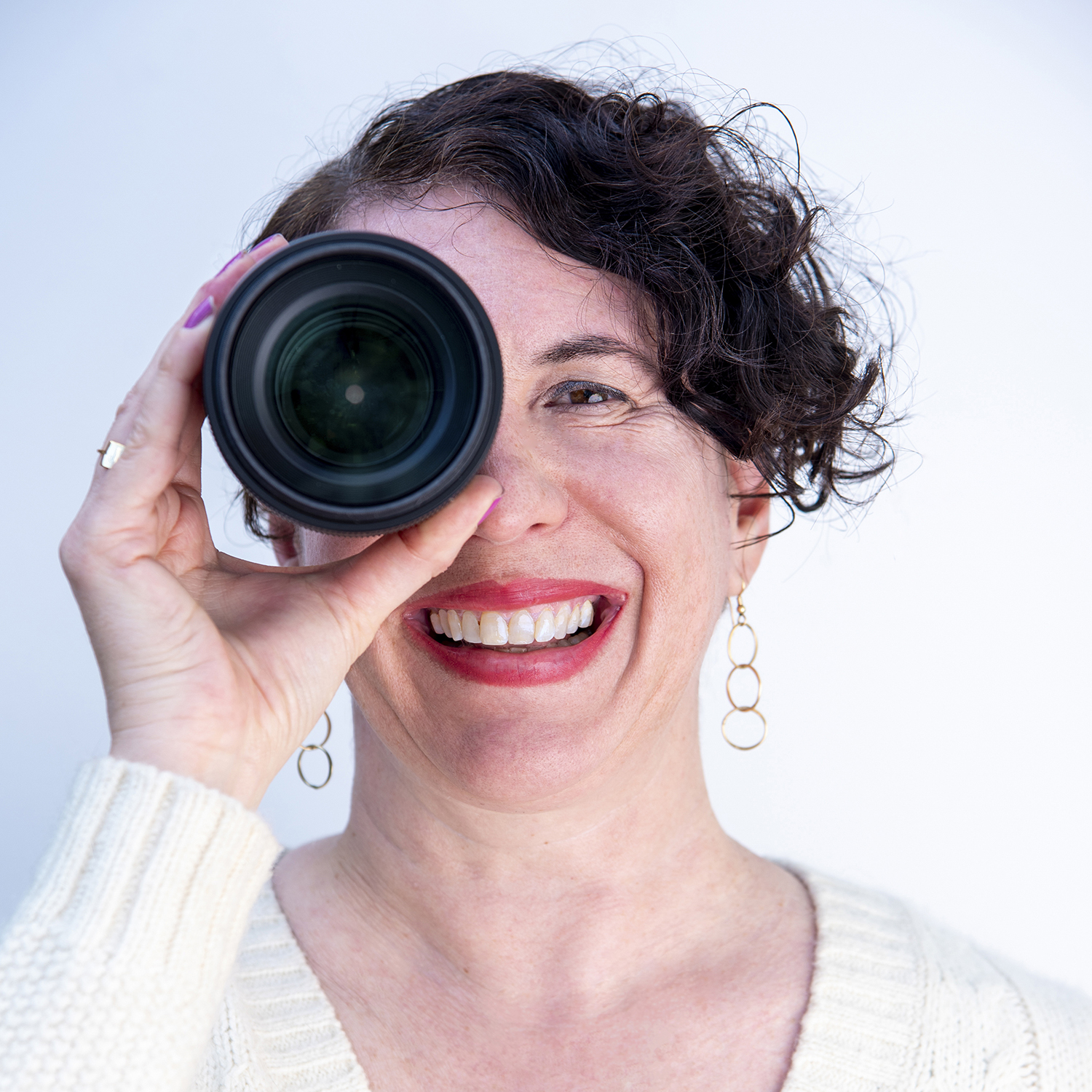 Photograph of Photographer Amy Tierney holding a lens up to her eye