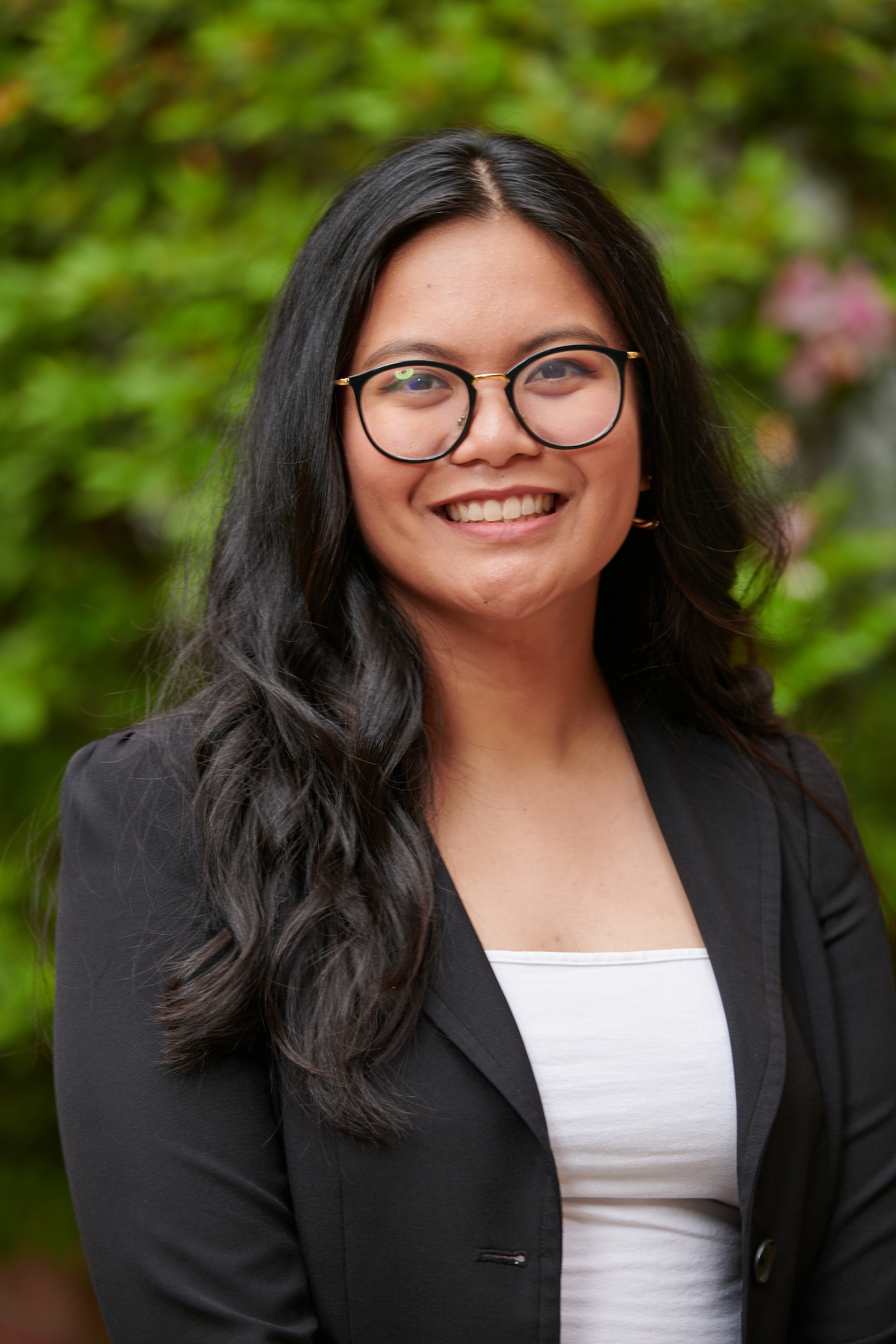 A professional headshot photo of Alyssa wearing glasses and blazer