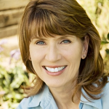 instructor with brown hair wearing blue shirt smiling at you