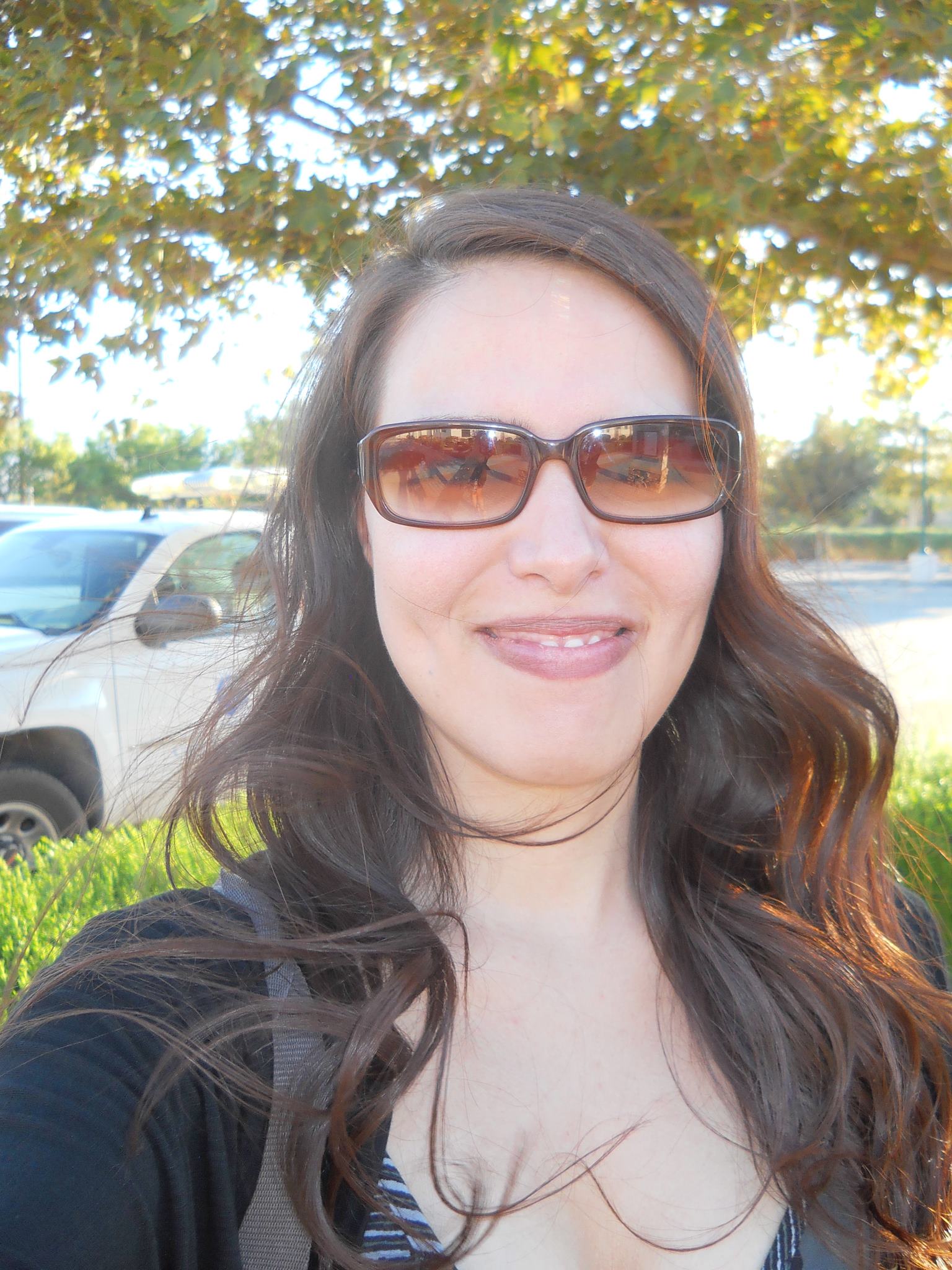 This is a photo of professor Guillen. She has long brown hair and is wearing sunglasses. She is outside on a sunny day.